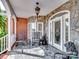 Inviting front porch with stone accents, rocking chairs, and elegant lighting, creating a cozy outdoor space at 6823 Manatee Dr, Concord, NC 28025