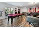 Entertaining game room featuring a pool table, ample seating, and attractive wood flooring at 6823 Manatee Dr, Concord, NC 28025