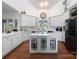 Spacious kitchen featuring white cabinets, hardwood floors, and black stainless appliances at 6823 Manatee Dr, Concord, NC 28025