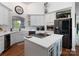 Bright kitchen featuring a spacious island, white cabinets, and hardwood floors at 6823 Manatee Dr, Concord, NC 28025