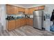 Functional kitchen equipped with wood cabinets, stainless steel refrigerator, and a double sink at 6823 Manatee Dr, Concord, NC 28025