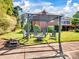 Inviting outdoor seating area with a pergola, comfortable chairs, and a fire pit on a green lawn at 6823 Manatee Dr, Concord, NC 28025