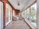 Long sun room featuring tile floor, red brick accent wall, and abundant natural light at 6823 Manatee Dr, Concord, NC 28025