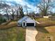 Aerial view of a modern home showcasing a long driveway, fenced-in backyard, and manicured lawn at 713 E Third Ave, Gastonia, NC 28054