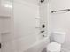 Bathroom showcasing a bathtub with shower, built-in shelves and toilet with modern hardware at 713 E Third Ave, Gastonia, NC 28054