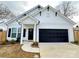 Charming home featuring a black garage door, a welcoming front door with a wreath, and well-maintained landscaping at 713 E Third Ave, Gastonia, NC 28054
