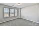 Bedroom with neutral walls and carpet features three windows for natural light at 8023 Downy Oak Ln, Charlotte, NC 28269