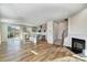Bright living room featuring hardwood floors, a fireplace, an island kitchen, and rear patio access at 8023 Downy Oak Ln, Charlotte, NC 28269