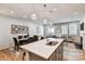Open-concept kitchen with a central island flowing into the dining and living spaces at 8027 Downy Oak Ln, Charlotte, NC 28269