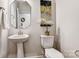 Charming powder room with pedestal sink, decorative mirror, and elegant toilet at 8027 Downy Oak Ln, Charlotte, NC 28269