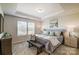 Inviting main bedroom features natural light, a tray ceiling, and neutral décor for relaxation at 8031 Downy Oak Ln, Charlotte, NC 28269