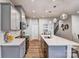 Modern kitchen with stainless steel appliances, grey cabinets, and a large island at 8035 Downy Oak Ln, Charlotte, NC 28269