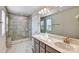 Bathroom features a double sink vanity and seamless glass shower with marble tiling at 8039 Downy Oak Ln, Charlotte, NC 28269
