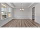 Bright dining room with hardwood floors, a modern chandelier, and wainscoting detail at 845 Regulus Ct, York, SC 29745