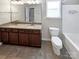 Bathroom featuring double vanity with granite countertops, dark cabinets, a toilet, and a shower/tub combo at 8804 Artesa Mill Ln, Charlotte, NC 28214