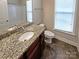 Bathroom showcasing granite vanity top, toilet, tile floor, and natural light at 8804 Artesa Mill Ln, Charlotte, NC 28214