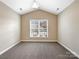 Bedroom with vaulted ceiling, neutral colors, carpet, and large windows with plenty of natural light at 8804 Artesa Mill Ln, Charlotte, NC 28214