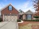 Charming brick home with a two-car garage, manicured landscaping, and a welcoming entrance at 8804 Artesa Mill Ln, Charlotte, NC 28214