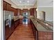 Well-equipped kitchen featuring granite countertops, stainless steel appliances, dark cabinets, and hardwood floors at 8804 Artesa Mill Ln, Charlotte, NC 28214