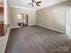 Open-concept living room with neutral carpet, ceiling fan, and arched doorway provides ample space at 8804 Artesa Mill Ln, Charlotte, NC 28214