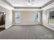 Spacious main bedroom with tray ceiling, carpet, large windows, and an ensuite bathroom at 8804 Artesa Mill Ln, Charlotte, NC 28214