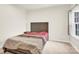 Cozy bedroom featuring carpet floors, a window, sleek modern furnishings and a neutral-toned comforter with red accents at 112 August Ln, Matthews, NC 28104