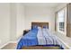 Bright bedroom with a window and carpet floors showcases a classic wooden headboard and colorful blue bedding at 112 August Ln, Matthews, NC 28104