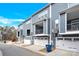 Townhome showcasing a well-maintained exterior with gray siding, balconies, and garages at 112 August Ln, Matthews, NC 28104