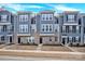 Charming townhome showcasing a well-maintained exterior with blue siding and brick accents at 112 August Ln, Matthews, NC 28104