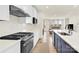 Bright kitchen featuring stainless steel appliances, white cabinets, an island with a sink, and an open floorplan at 112 August Ln, Matthews, NC 28104