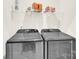 Modern laundry room with washer and dryer plus overhead storage shelves at 112 August Ln, Matthews, NC 28104