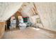 Unfinished attic space with exposed rafters, spray foam insulation, and a variety of storage containers at 1328 S Kings Dr, Charlotte, NC 28207