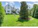 Expansive backyard featuring lush green lawn, mature trees, and a charming white brick home at 1328 S Kings Dr, Charlotte, NC 28207