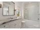 Bright bathroom with glass-enclosed tub, marble vanity, sleek fixtures and stylish black and white tile at 1328 S Kings Dr, Charlotte, NC 28207