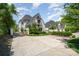 Gated entrance with a long driveway leading to a white brick home with manicured landscaping at 1328 S Kings Dr, Charlotte, NC 28207