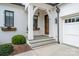 Inviting front porch with stone steps, white columns, and a dark wood door with decorative planters at 1328 S Kings Dr, Charlotte, NC 28207