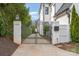 A decorative metal gate flanked by white brick pillars secures the entrance to the property at 1328 S Kings Dr, Charlotte, NC 28207