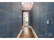 Hallway with hardwood floors and striking blue wallpaper with gold accents at 1328 S Kings Dr, Charlotte, NC 28207