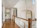 Open hallway featuring hardwood floors, staircase, chandelier, and artwork-adorned walls at 1328 S Kings Dr, Charlotte, NC 28207