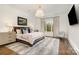 Main bedroom with large bed, neutral colors, and hardwood floors at 1328 S Kings Dr, Charlotte, NC 28207