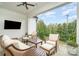 Covered porch features comfortable seating, ceiling fan, exterior lights and TV for outdoor enjoyment at 1328 S Kings Dr, Charlotte, NC 28207