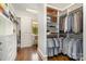 Spacious walk-in closet with custom shelving, hanging rods, drawers, and hardwood floors at 1328 S Kings Dr, Charlotte, NC 28207