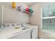 This functional laundry room includes modern washer and dryer, shelving, and a bright window at 1348 Southern Sugar Dr, Charlotte, NC 28262