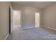 Spacious bedroom with neutral walls, plush carpet, and two doorways leading to bathroom and closet at 14106 Yachtsman Harbor Dr, Charlotte, NC 28278