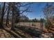 Outdoor tennis court surrounded by trees; offering a private and picturesque setting for sports enthusiasts at 14106 Yachtsman Harbor Dr, Charlotte, NC 28278