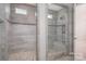 Modern bathroom featuring dual tiled walk-in showers with mosaic accents and glass doors at 146 Stibbs Cross Rd, Mooresville, NC 28115