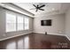 Spacious bedroom with dark hardwood floors, a ceiling fan, large windows, and a tray ceiling at 146 Stibbs Cross Rd, Mooresville, NC 28115
