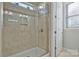 Modern glass enclosed shower stall with tan tile surround and decorative tile accent at 1496 Imperial Ct, York, SC 29745