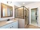 Elegant bathroom featuring a glass-enclosed shower, neutral tiles, framed mirror, and granite countertops at 19843 Lamp Lighters Way, Cornelius, NC 28031