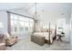 Serene bedroom with a four-poster bed, sitting area, and large windows with natural light at 2016 Thatcher Way, Fort Mill, SC 29715